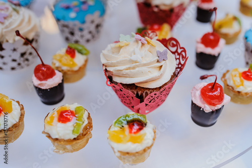 sweet cupcakes with cherry, kiwi, orange