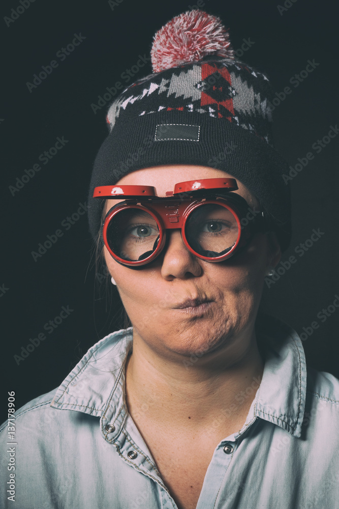 Young girl doing funny faces in red glasses and a cap Young girl doing funny faces in red glasses and a cap