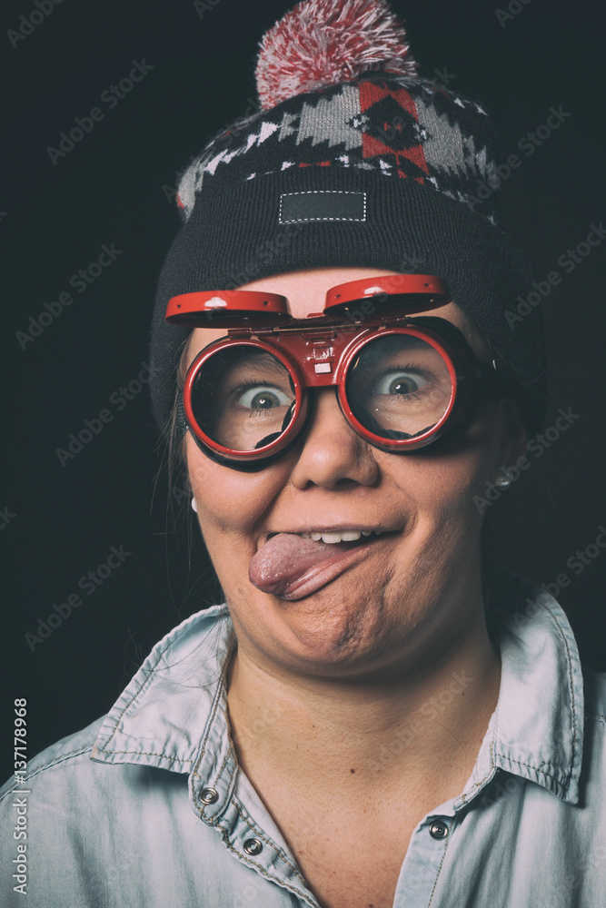 Young girl doing funny faces in red glasses and a cap Young girl doing funny faces in red glasses and a cap
