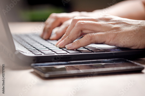 Close up of business woman hand typing on laptop keyboard, lighting effect