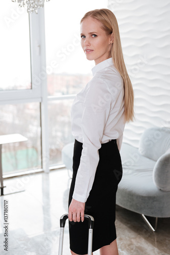Free Download Pretty business woman standing in office holding suitcase. - GFXLoad