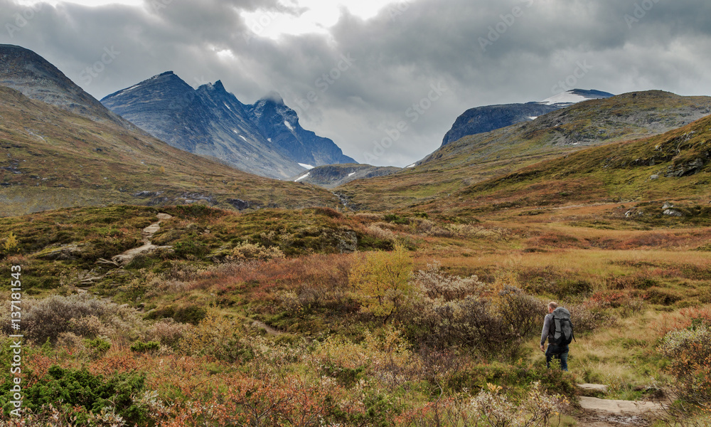 Man walks towards the mountains of Hurrungane in Jotunheimen, Norway