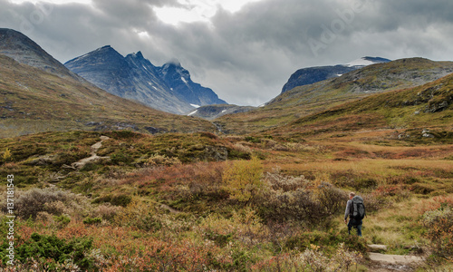 Man walks towards the mountains of Hurrungane in Jotunheimen, Norway © Lillian