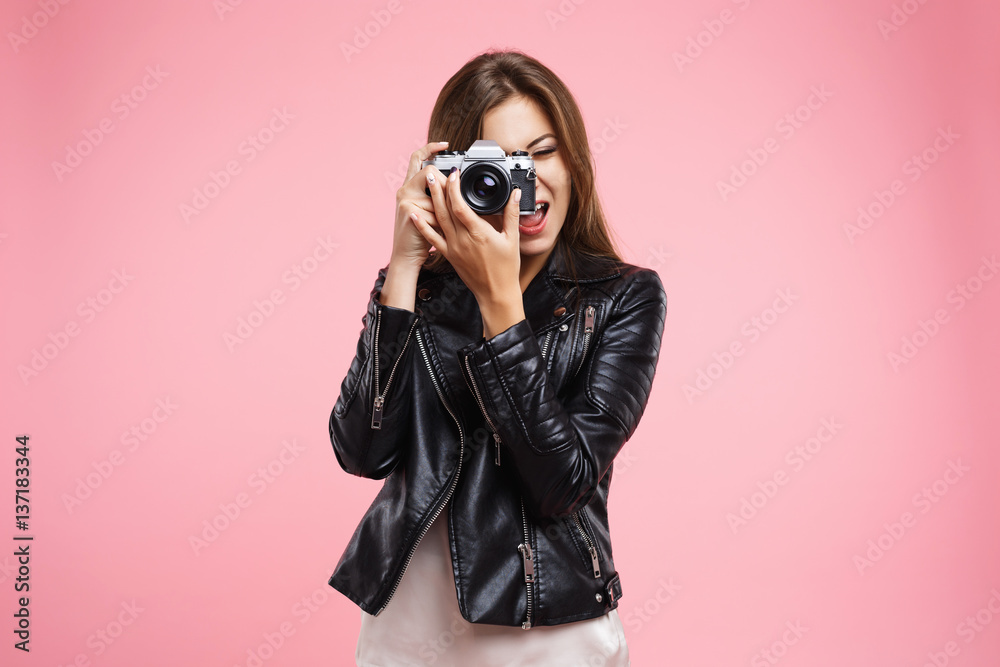 Fashion girl in black leather jacket holding old camera Fashion girl in black leather jacket holding old camera