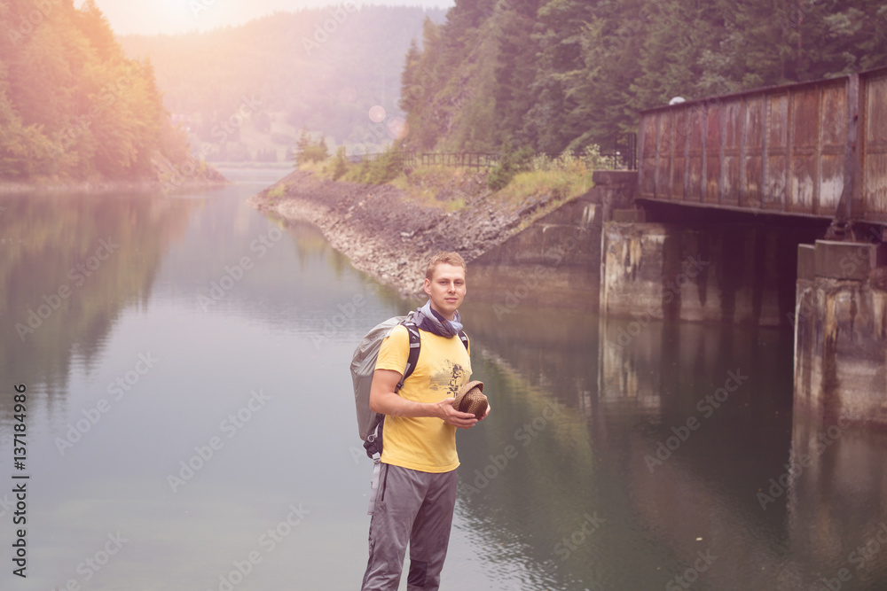 man standing under bridge across river travel concept man standing under bridge across river travel concept