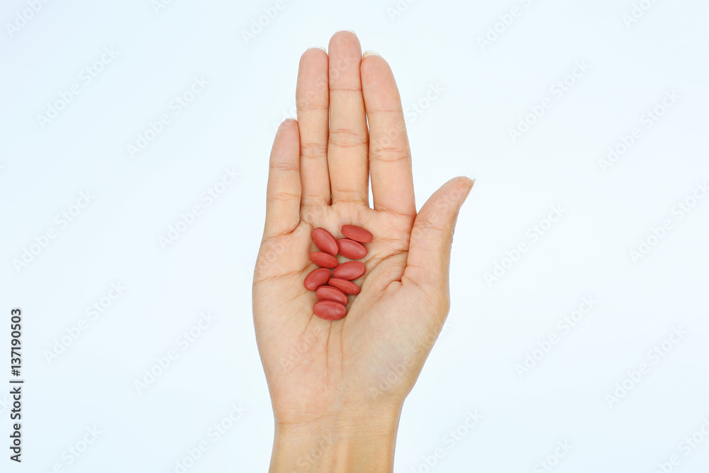 Close-up hand of a woman with some pills on white background Close-up hand of a woman with some pills on white background