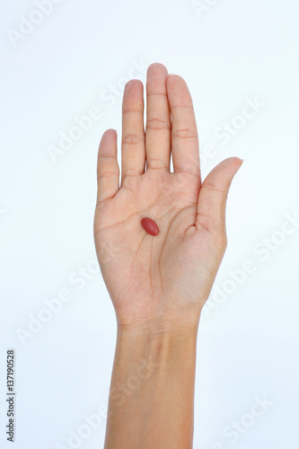 Close-up hand of a woman with some pills on white background