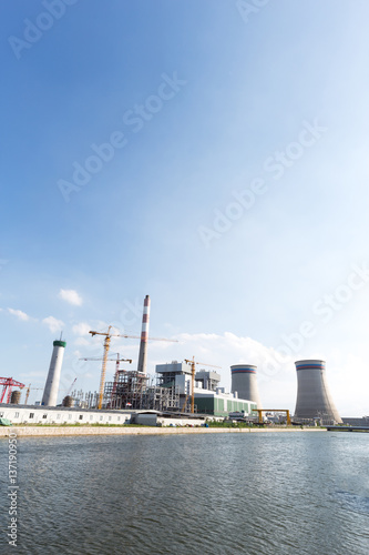modern power plant near river in blue sky