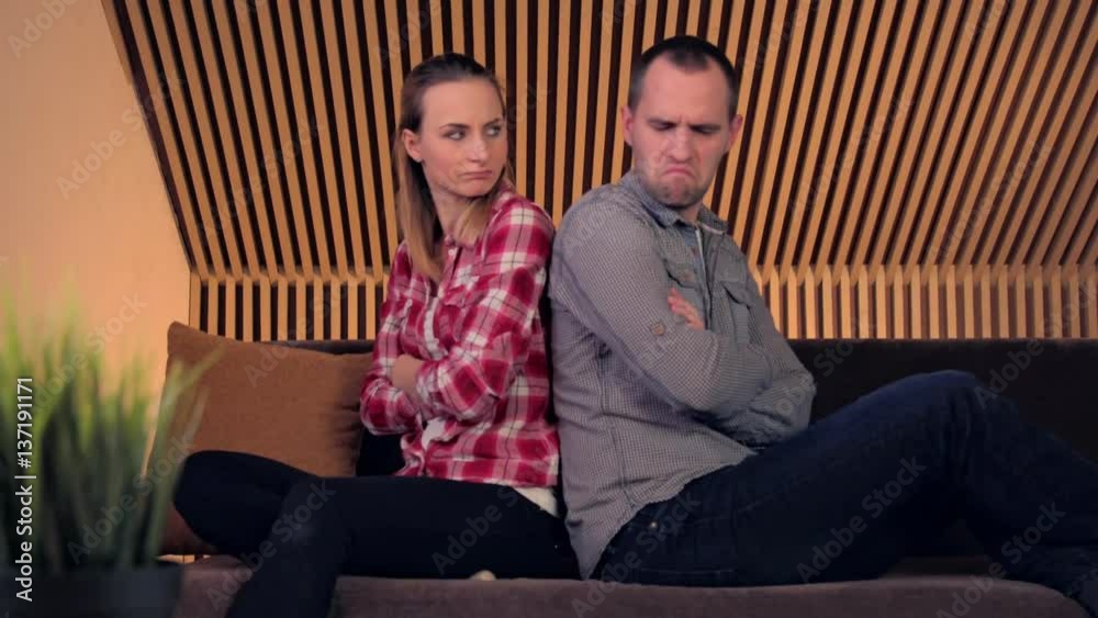 Offended, angry couple sitting on sofa at home Offended, angry couple sitting on sofa at home