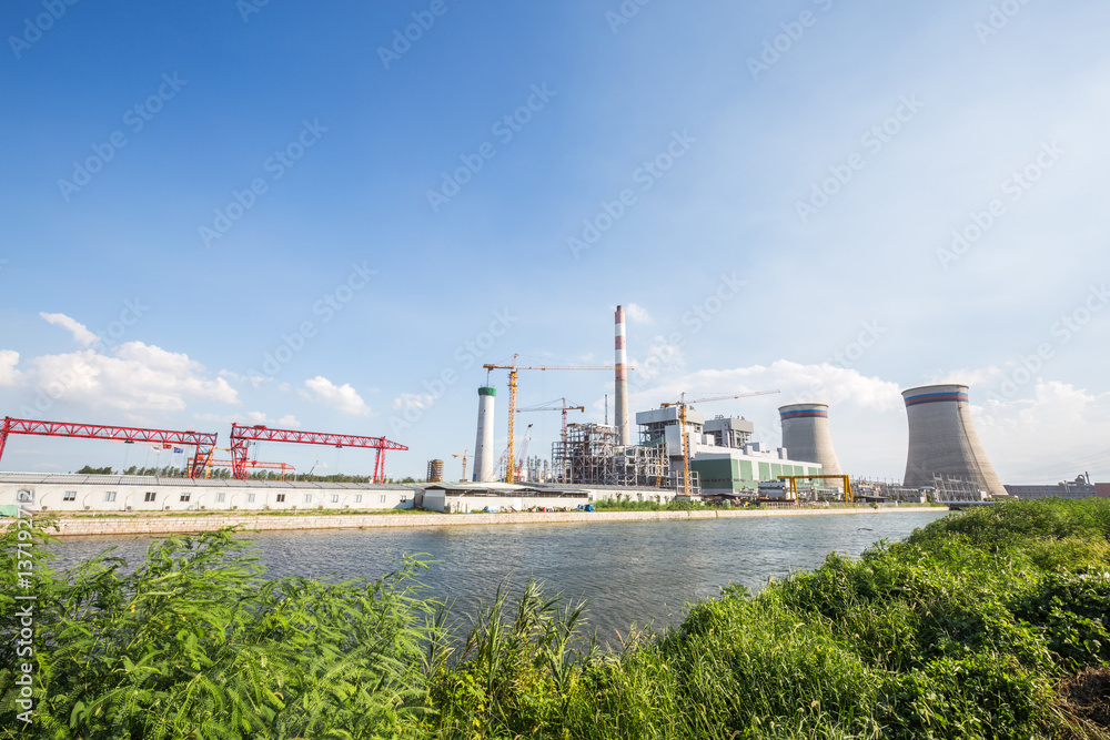 modern power plant near river in blue sky modern power plant near river in blue sky