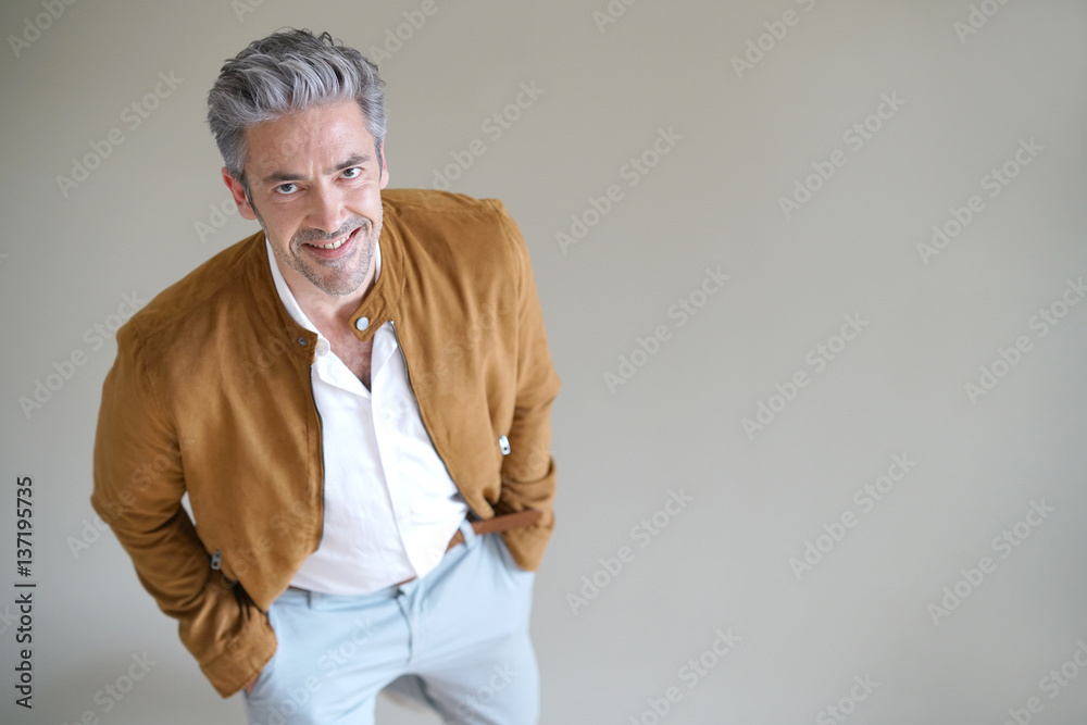 Mature man standing on grey background, isolated Mature man standing on grey background, isolated