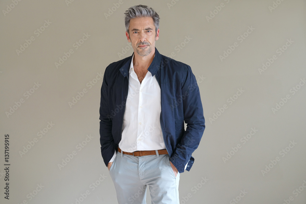 Handsome mature man standing on grey background, isolated - obrazy, fototapety, plakaty 