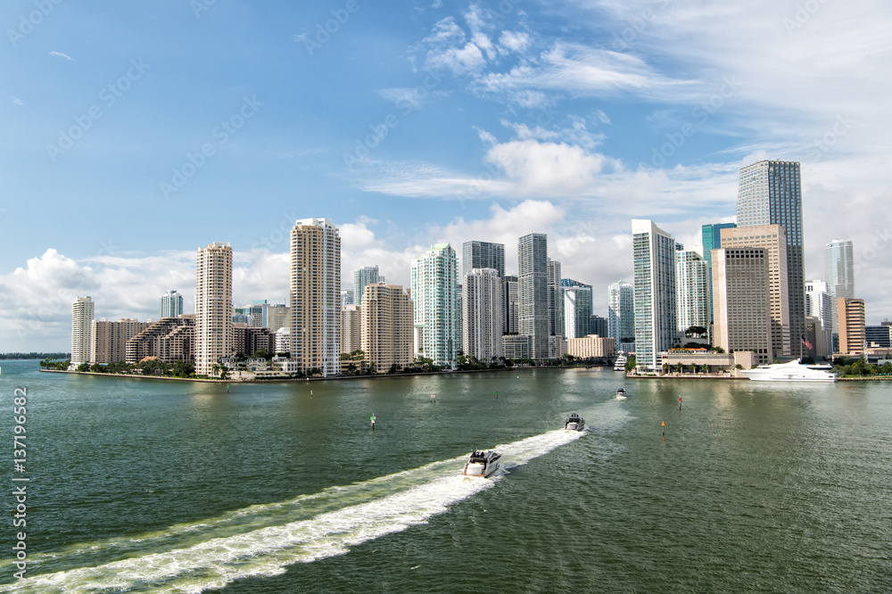 Fototapeta premium Aerial view of Miami skyscrapers with blue cloudy sky, boat sail