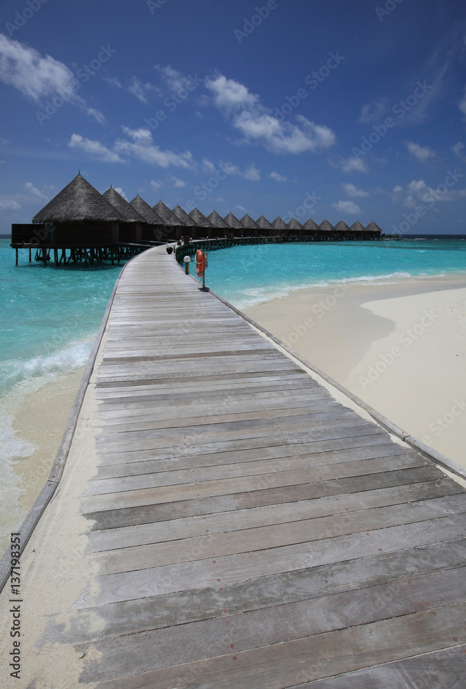 Traditional Maldives bungalows on wooden pier in tropical paradise