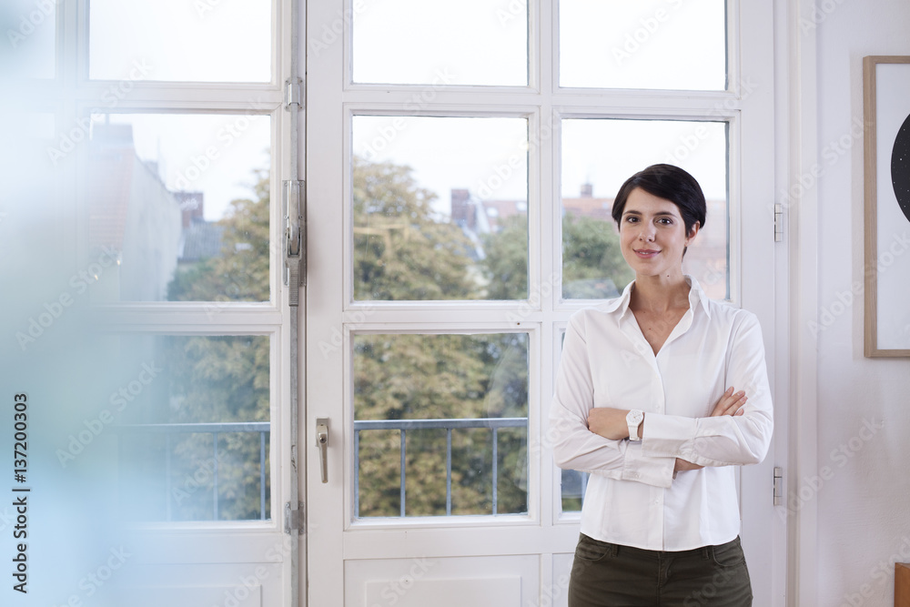 Portrait of confident woman standing at the window Portrait of confident woman standing at the window