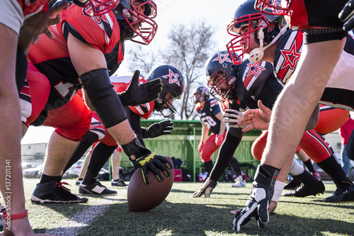 American football players on the line of scrimmage during a match