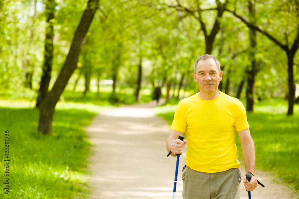 Happy elderly people engaged in Nordic walking Happy elderly people engaged in Nordic walking