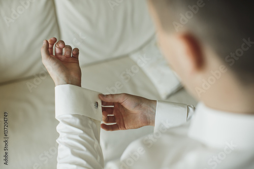 close up of a hand man how wears white shirt and cufflink © Artem Zakharov