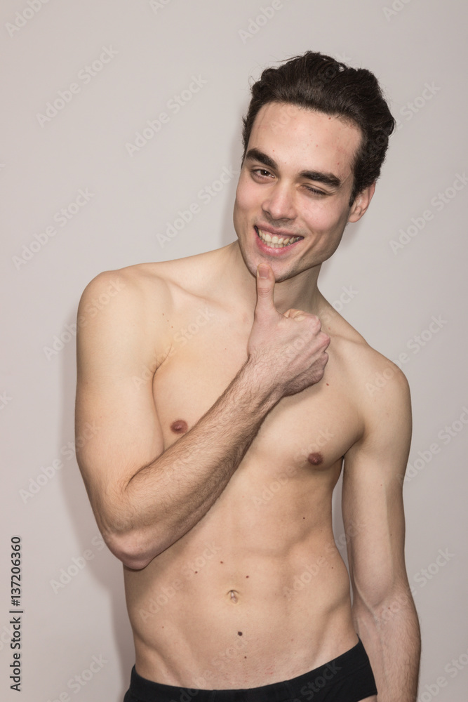 young man shirtless model posing winking