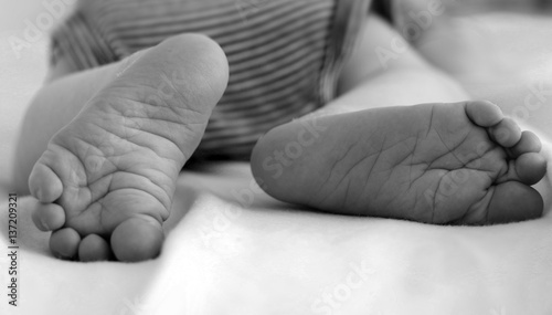 Feet of baby sleeping on belly in black and white