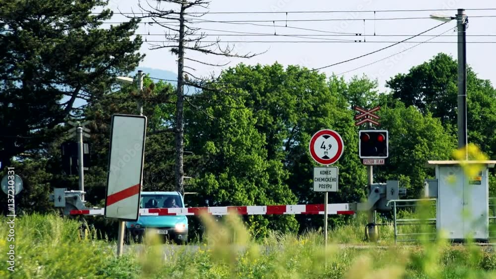 Crossing barriers go down while a car waits