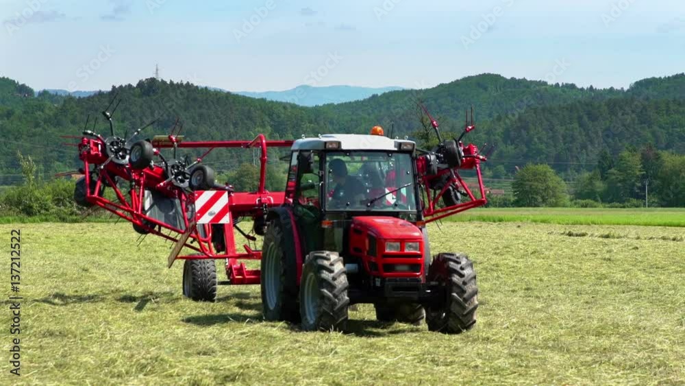 The machinery is slowly folding together when a farmer is pushing a button inside a tractor.
The machinery is slowly folding together when a farmer is pushing a button inside a tractor.