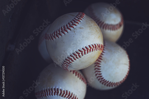 Old baseballs in a pile, perfect for sports or athletic background.