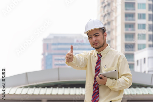 Business man thumbs thumb A confident stance, with the backdrop of the buildings in the city.