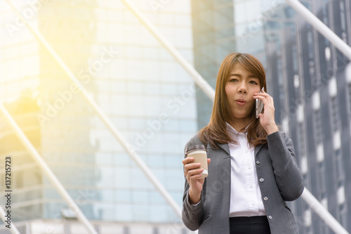 Business woman using a communication tool. The background is a building in the city.