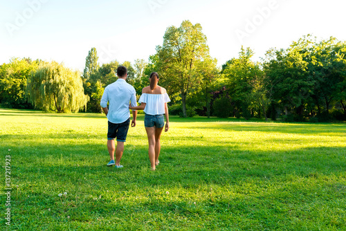 Beautiful young couple walking together in the park 
