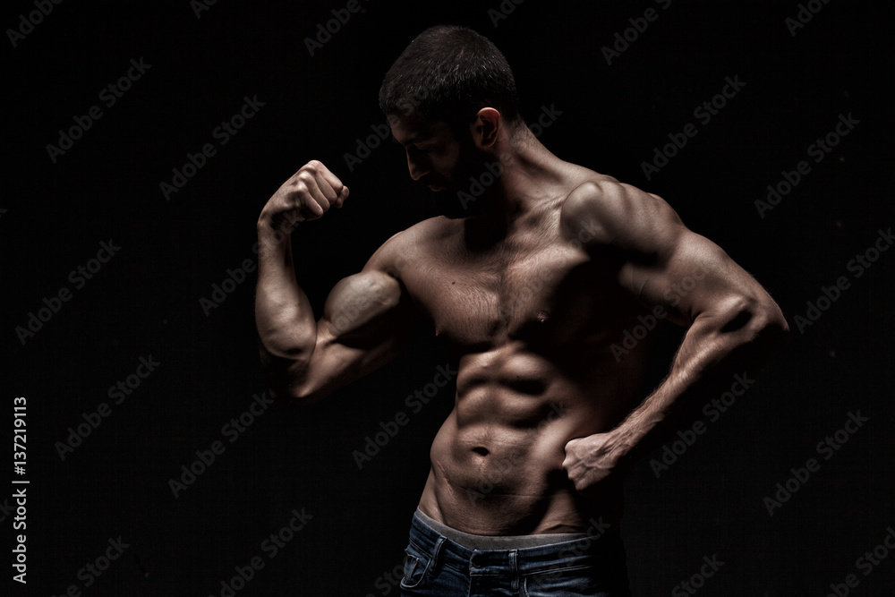 studio portrait of athlete bodybuilder man isolated over black background