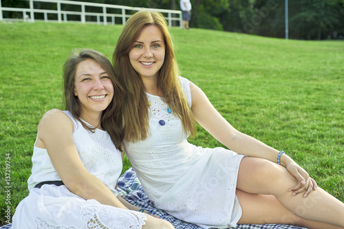 two friends lying on the grass in the park