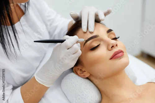 Obraz Beautician Doing Permanent Eyebrows Makeup Tattoo On Woman Face