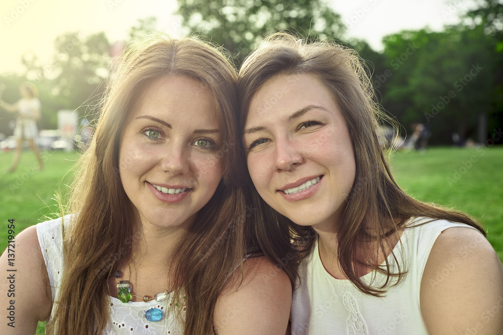 two friends lying on the grass in the park two friends lying on the grass in the park