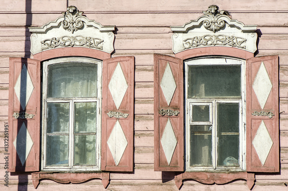 Carved wooden decorative lace decoration windows. Old wooden house.