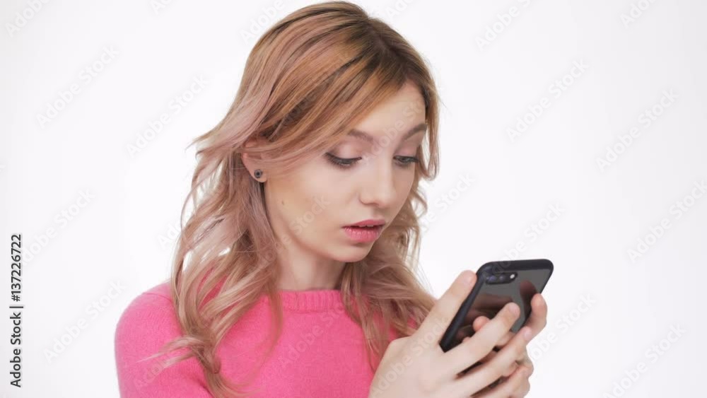 Shocked Woman in pink sweater which writing message on phone
Shocked Woman in pink sweater which writing message on phone