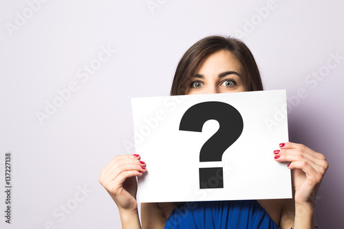 Fototapeta Girl holding a signboard with a question mark