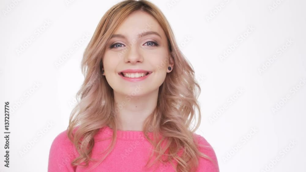 Smiling Woman in pink sweater saying i love you and looking at camera Smiling Woman in pink sweater saying i love you and looking at camera