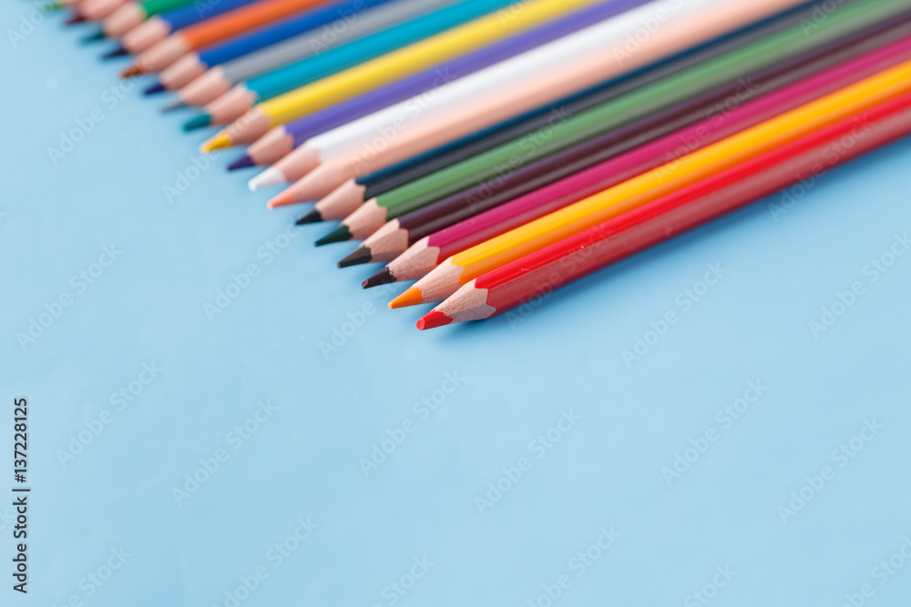 Full row of multycolor pencils on blue background Full row of multycolor pencils on blue background