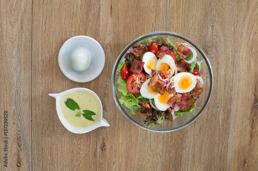 Salad egg boiled in bowl with boiled egg and salad sauce on the brown table