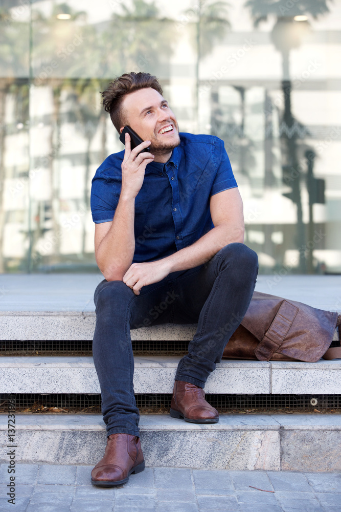 happy guy sitting outside with cell phone happy guy sitting outside with cell phone