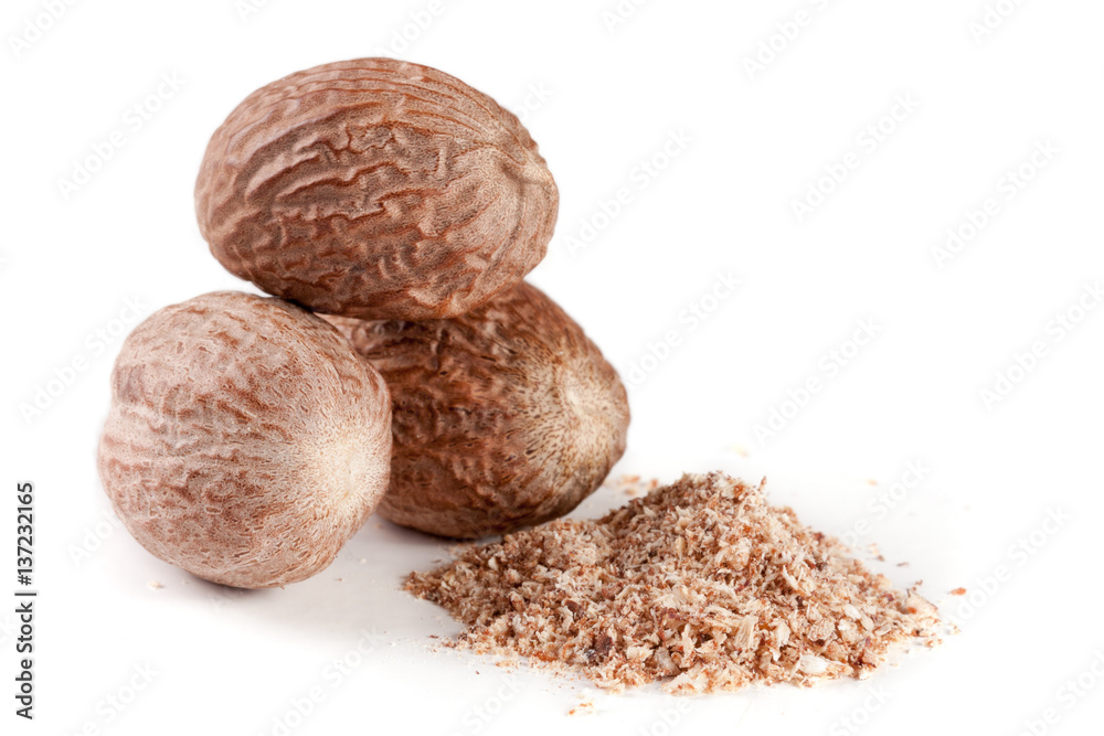 Three nutmeg and powder isolated on white background Three nutmeg and powder isolated on white background