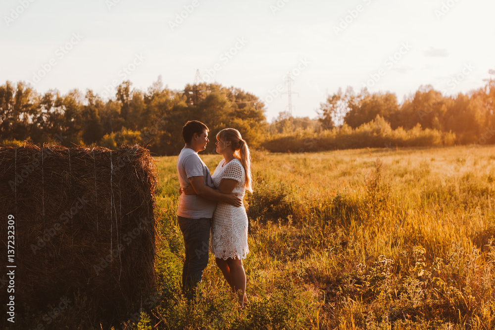 Φωτογραφία love story man and woman on the background of haystacks  sun