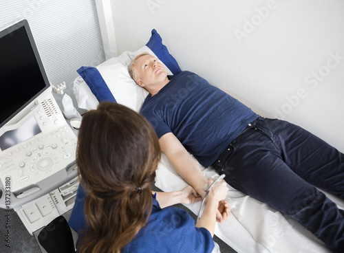 Doctor Using Ultrasound Probe On Male s Wrist In Hospital