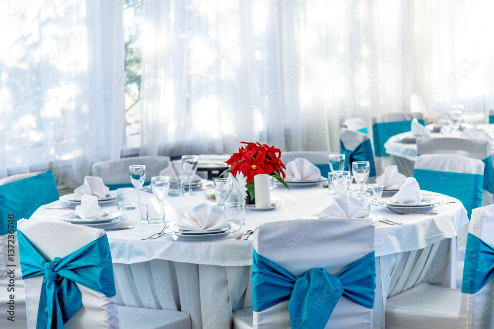 Round white table with a tablecloth set for dinner in a country restaurant. Round white table with a tablecloth set for dinner in a country restaurant.