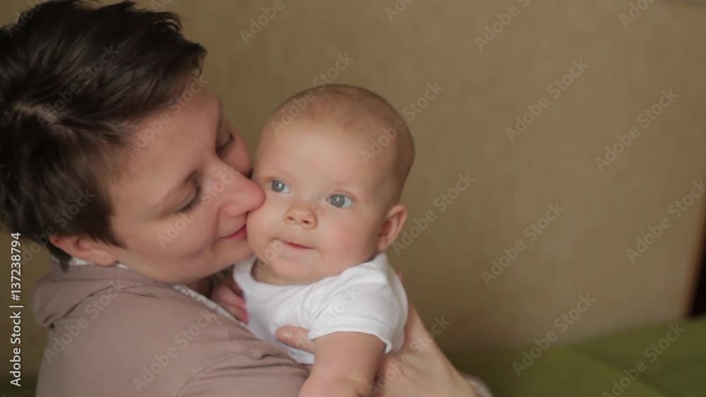young pretty mother kissing her little baby with love young pretty mother kissing her little baby with love