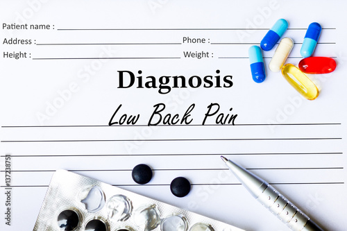 Low Back Pain - Diagnosis written on a piece of white paper with medication and Pills