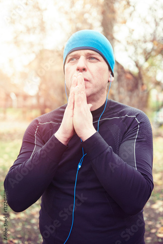 Mature man outdoors, wearing sports clothing, hands together photo