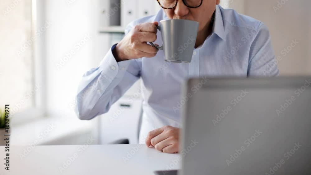 businessman with laptop drinking coffee at office businessman with laptop drinking coffee at office