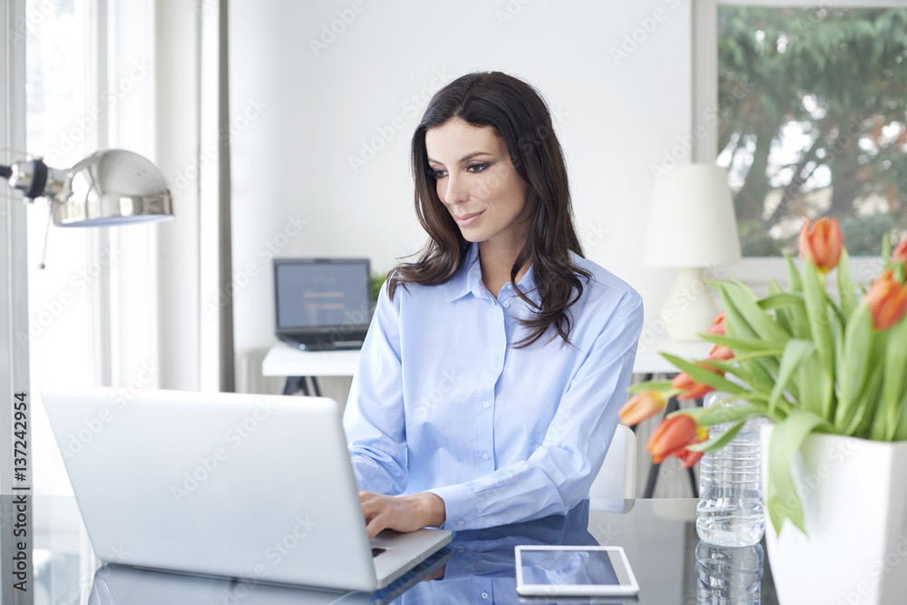 Getting focused on the new project. Professional businesswoman working on laptop at office Getting focused on the new project. Professional businesswoman working on laptop at office